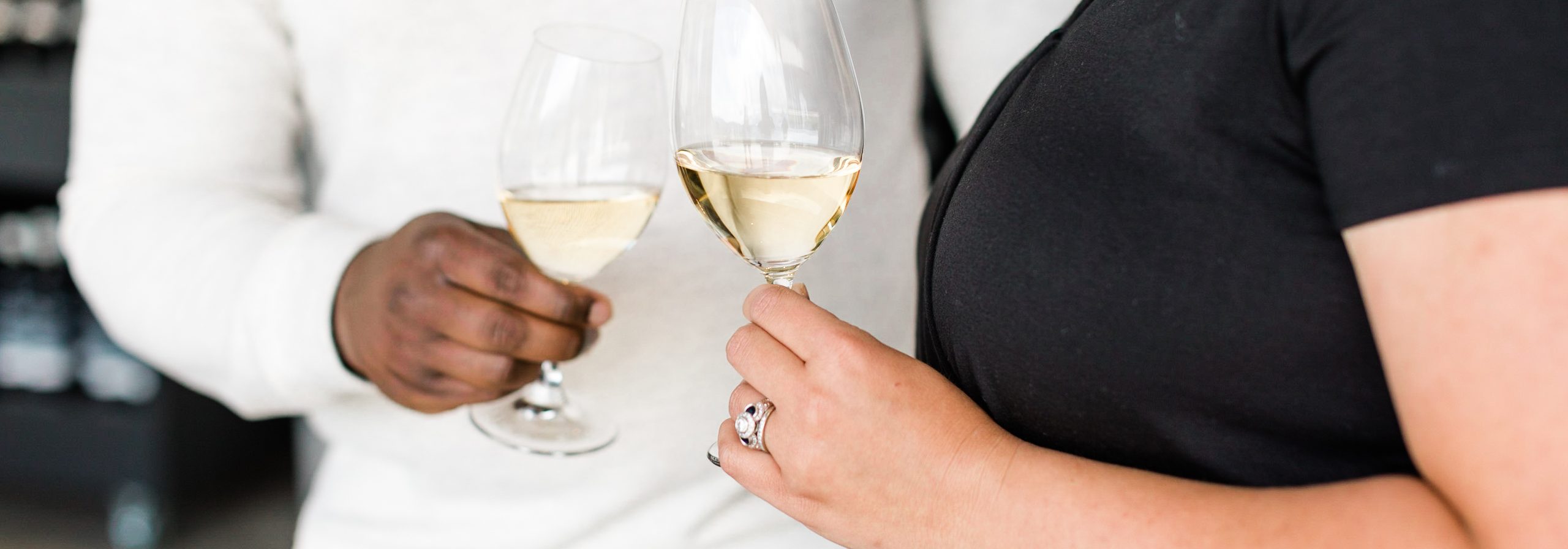 Inter-racial couple holding wine glasses close together